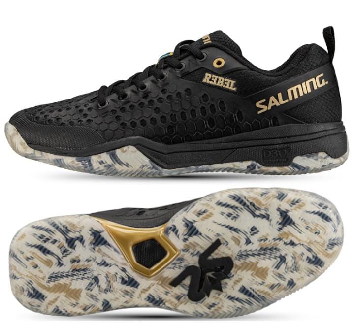 A pair of Salming Rebel Men's Indoor Court Shoes in black and gold, featuring a honeycomb texture. The shoes are designed for stability and grip, with soles accented in white, gray, and gold. The brand "Salming" is displayed in gold, while the model name is imprinted on the side in yellow.