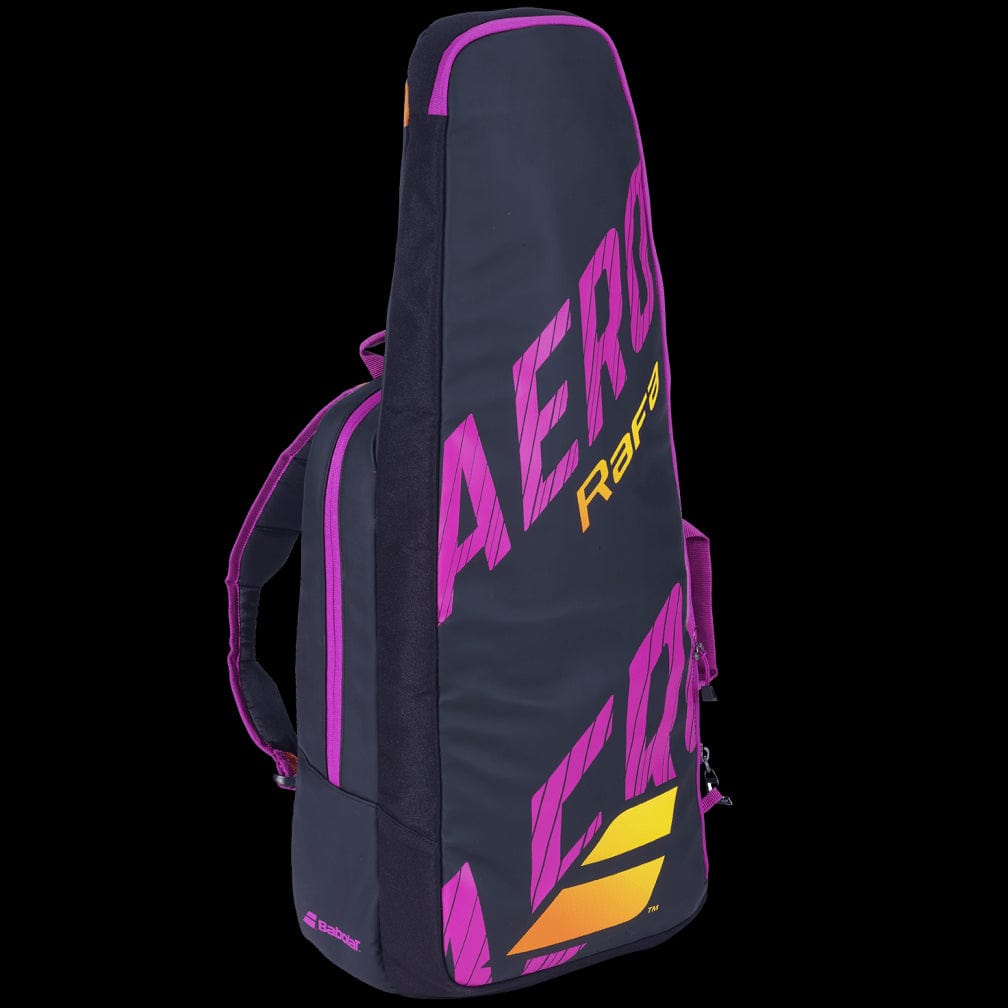 The Babolat Pure Aero RAFA Tennis Backpack stands out with its sleek black design, highlighted by vibrant pink and yellow elements. "Aero" is prominently displayed in pink, accompanied by a comfortable pink shoulder strap. The iconic Babolat brand logo graces the side, reflecting its signature style.