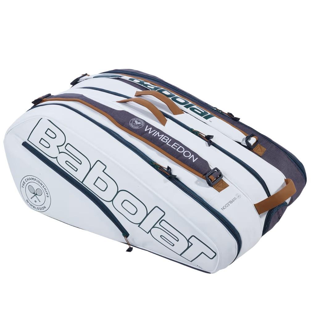 The Babolat RH12 Pure Wimbledon 12 Racket Tennis Bag stands out in white and grey, featuring the "Wimbledon" print. It offers multiple compartments with secure zipper closures and stylish beige handles, while circular logos enhance its chic design.