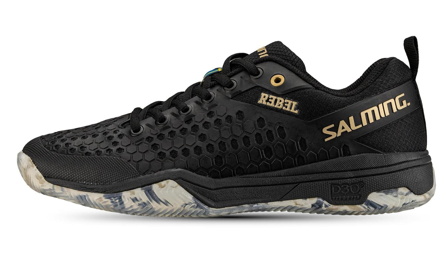 Introducing the Salming Rebel Mens Indoor Court Shoe in Black/Gold: these stylish black sports shoes from Salming feature a distinctive hexagonal pattern on the sides and gold "REBEL" and "SALMING" logos. Crafted for superior grip and stability, they come with a white and gray patterned sole and a black lace-up front.