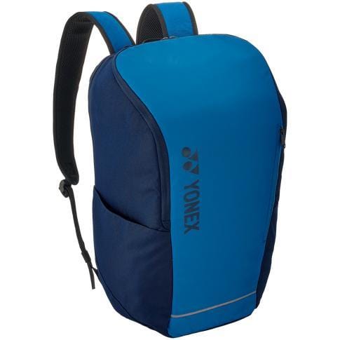 The Yonex 42312SEX Team Backpack in sky blue offers a sleek design complete with adjustable shoulder straps and convenient side pockets. Ideal for racket sports enthusiasts, this backpack prominently displays the Yonex logo printed vertically on the front.
