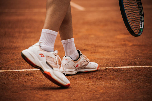 Yonex tennis shoes on a clay court