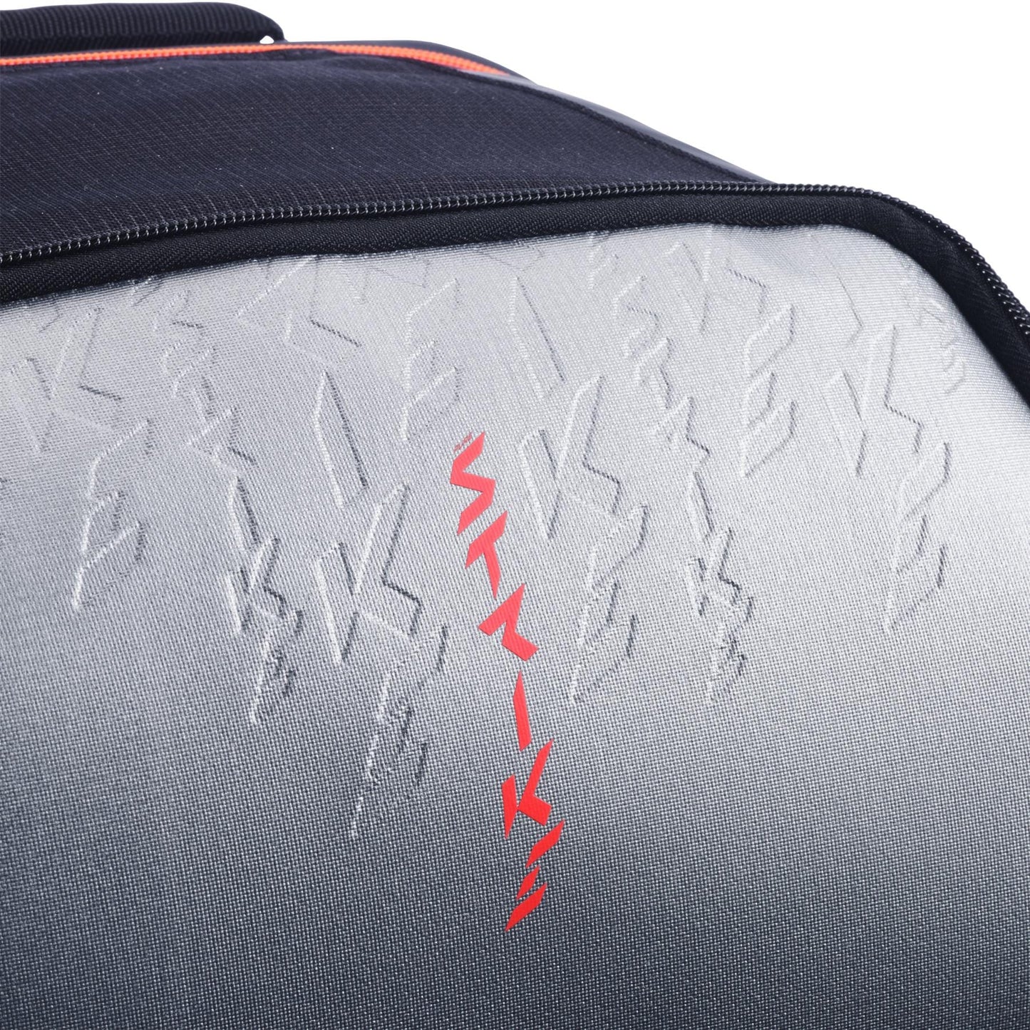 Close-up of the textured carbon grey and black surface of the Babolat Pure Strike Tennis Backpack, featuring embossed patterns and a central vertical line of red symbols.
