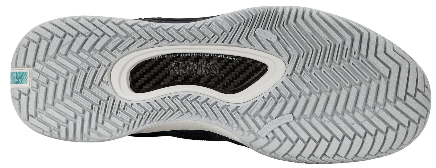 Close-up of the outsole of the K-Swiss Hypercourt Pinnacle Men's Tennis Shoe in Carbon / White / Baltic, showcasing a gray, wavy herringbone traction pattern, a transparent window that reveals a carbon fibre plate, and a small turquoise label on the left side.