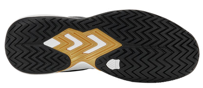 Close-up of the sole of the K-Swiss Ultrashot Light Men's Tennis Shoes in Moonless Night, White, and Gold—featuring a black zigzag tread, gold and white geometric accents, and a small textured white section near the arch that highlights the distinctive lightweight court shoe design by K-Swiss.