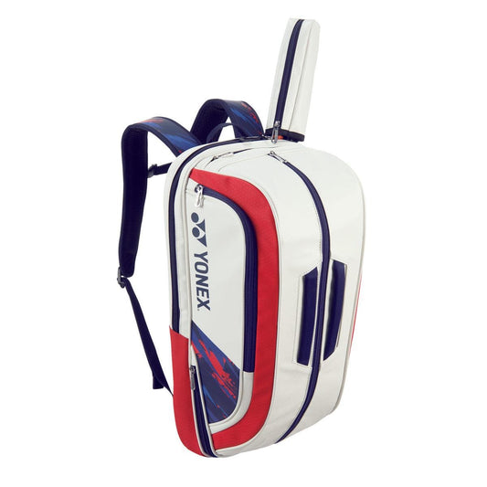 The Yonex 02312EX Expert Backpack in White and Red features multiple zippered compartments, shoulder straps, and a convenient shoe pocket. Its slightly angled display highlights its volume, design, and versatility as an ideal choice for avid tennis players.