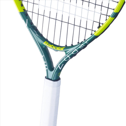 Close-up of the Babolat Wimbledon 21 Junior Tennis Racket. The frame is green with yellow accents, and the grip is wrapped in white. "Babolat" proudly adorns the neck of this aluminium racket, perfect for rising champions.
