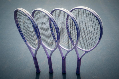 Four HEAD Boom MP UL Alternate 2026 Tennis Rackets by HEAD, featuring purple handles, stand upright and lean against each other on a tennis court, casting distinct shadows on the ground.
