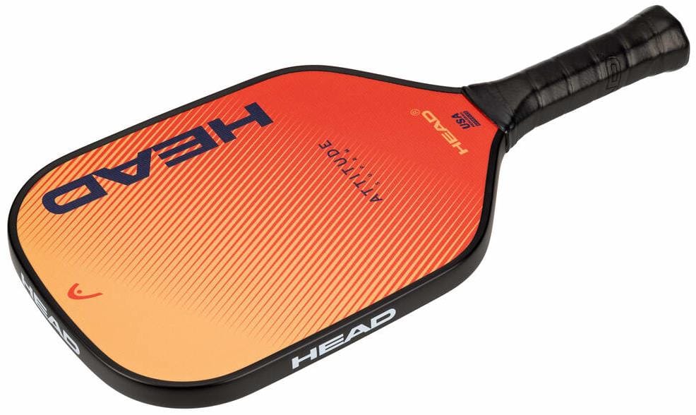 The HEAD Attitude SUPRM Pickleball Paddle features an orange and yellow design with a black grip, large blue "HEAD" branding on the face, and is ideal for beginner pickleball players.