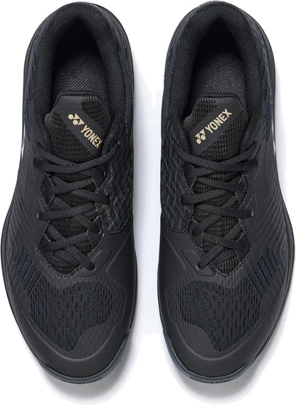 A pair of Yonex Power Cushion Sonicage Men’s Tennis Shoes in Black/Mocha Grey, viewed from above, featuring mesh uppers, black laces, textured details, and gold Yonex logos on the tongues for a lightweight tennis experience.