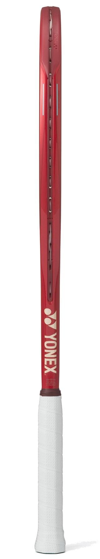 The Yonex 08 VCORE 100L 2026 Tennis Racket in Ruby Red is shown from the side, featuring a white grip and visible string holes along the frame, emphasizing its impressive spin potential.