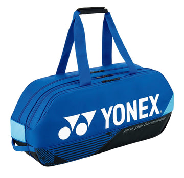 The Yonex 92431WEX Pro Tournament 6 Racket Tennis Bag in cobalt blue is ideal for professional tournament use, featuring black and light blue accents. It comes with dual handles, a logo on the side, and two zippered compartments perfect for storing rackets and other sports equipment.