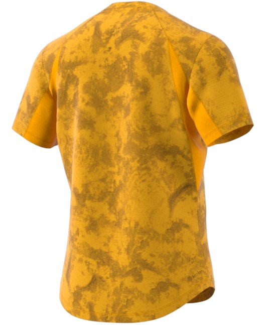 The ADIDAS Paris Men's Freelift Tennis T-Shirt in Gold/Yellow, crafted by adidas, is a short-sleeved shirt perfect for tennis. It features a vibrant yellow and orange abstract pattern on the back, resembling a watercolor texture that provides a visually dynamic effect both on and off the court.