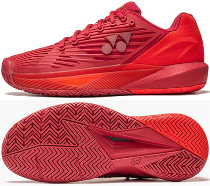 The Yonex Power Cushion Eclipsion 5 Women’s Tennis Shoes in Ruby Red feature textured soles, a geometric side pattern, and a round sole design with the Yonex logo, shown from both side and bottom views.