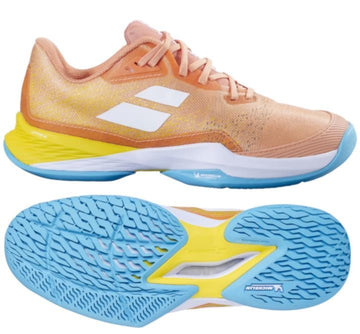 The Babolat Jet Mach 3 2024 Women's Tennis Shoes in Coral and Gold Fusion feature an orange and peach upper with a white logo on the side, bright blue Michelin soles, and a yellow accent on the heel. These shoes incorporate Matryx technology for enhanced grip with a textured sole.