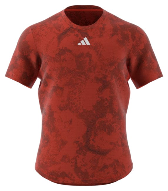 Introducing the ADIDAS Paris Men's Freelift Tennis T-Shirt in red, designed by adidas. This sports t-shirt for men features a subtle abstract pattern, alongside a small white logo on the chest. Engineered with HEAT.RDY technology, it offers ultimate breathability, making it ideal for intense matches or casual training sessions.