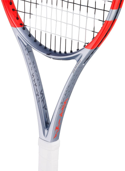 A close-up of a Babolat Pure Strike Team Gen4 Tennis Racket in Carbon Grey shows the silver and red frame, black strings, and white grip at the throat and handle—ideal for players wanting control and forgiveness.