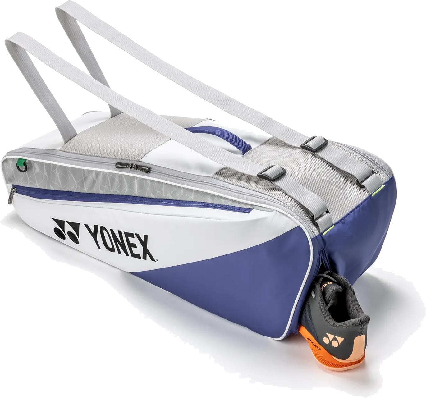 A Yonex BA52526EX Club 6 Racket Tennis Bag in white and blue, featuring two shoulder straps, sits partially unzipped to show an orange Yonex shoe inside.