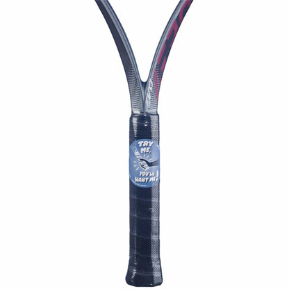 A close-up of the Babolat Evo Aero Pink 2026 Tennis Racket handle wrapped in black grip tape, with a "TRY ME, YOU'LL WANT ME!" sticker and a hand pointing—perfect for intermediate to advanced players.