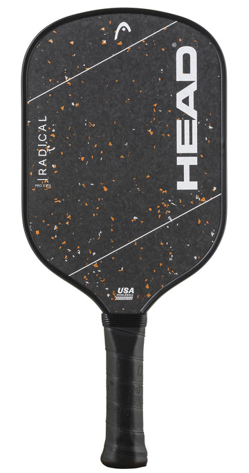 The HEAD Radical Pro EX15 2026 Pickleball Paddle by HEAD features a black and orange speckled face accented with white diagonal lines and the large, bold "HEAD" logo in white. Its raw carbon surface is designed to enhance spin and control, while the handle is wrapped in black grip tape for added comfort.