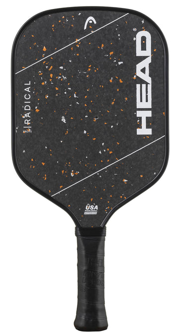 The HEAD Radical Pro 15 2026 Pickleball Paddle is a black paddle from HEAD, featuring a TriFlex Versatility Core and a textured, raw carbon surface. It is accented with white diagonal stripes, orange specks, and has a black grip. Both the HEAD logo and the USA Pickleball logo are visible on the paddle.