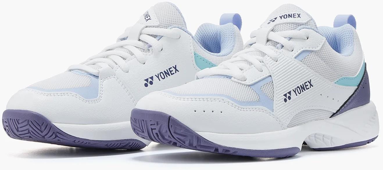 A pair of Yonex Pro-Move Classic Junior Tennis Shoes in white/sax, featuring light purple soles, blue and purple accents, breathable mesh detailing, and Power Cushion Technology by Yonex, placed side by side on a white background.