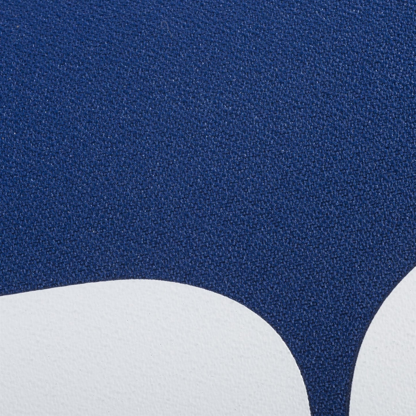 Close-up of a textured surface with a curved white shape below deep blue, inspired by the sleek Babolat Court XS 3 Racket Tennis Bag - Blue—ideal for fans of abstract or minimalist design and the renowned Babolat brand.