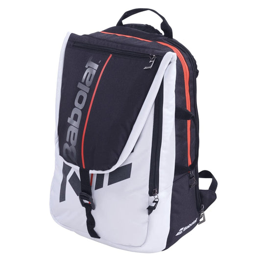 The Babolat Pure Strike Tennis Backpack - White / Red showcases a sleek and sporty design featuring black and white colors accented by red highlights. It offers multiple compartments, including an isothermal insulated section for tennis essentials, a front flap proudly displaying the Babolat logo, and side zippers for additional storage.