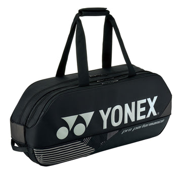 The Yonex 92431WEX Pro Tournament 6 Racket Tennis Bag in black features a sleek and streamlined design with two carry handles and a prominent logo. Engineered for professional performance, it includes multiple compartments ideal for organizing your rackets.