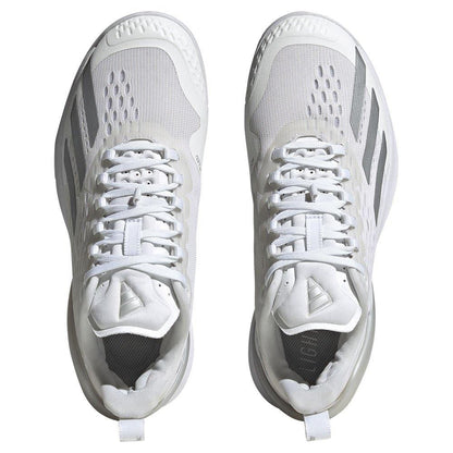A top-down shot reveals a pair of women's tennis shoes in white, accented with silver, characterized by mesh uppers and unique stripe designs on the sides. These Adidas Adizero Cybersonic sneakers are equipped with lace-up closures and cushioned soles for enhanced comfort, style, and swift movement.