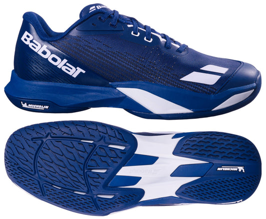 The Babolat Jet Mach 4 All Court Men's Tennis Shoes in dark blue and white feature the brand logo on the side and a textured, two-tone sole shown from both side and bottom views.