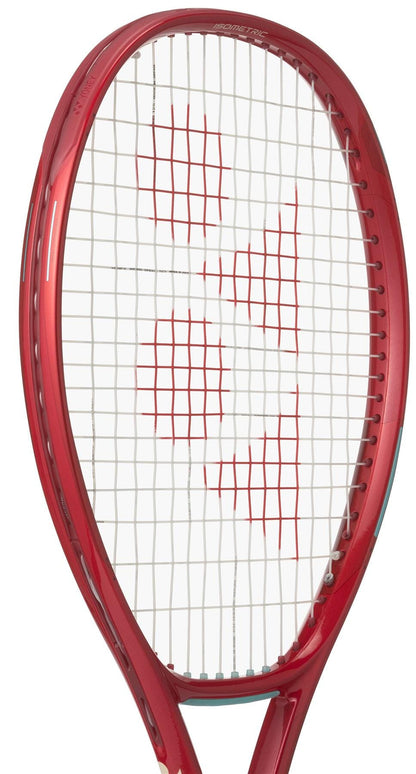 A close-up of the Yonex VCORE 100 Ruby Red 2026 Tennis Racket, featuring white strings and a red geometric center pattern, designed by Yonex to maximize spin.