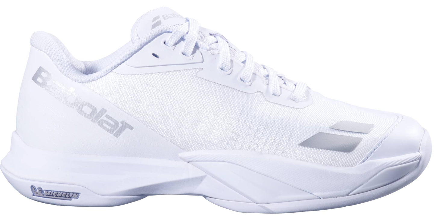 The Babolat Jet Mach 4 All Court Women's Tennis Shoes in White/Silver feature a low profile, mesh upper, rubber sole for agility, and display the Babolat logo on the side and Michelin logo on the heel of the sole.
