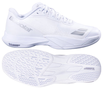 The Babolat Jet Mach 4 All Court Women's Tennis Shoes in white and silver are shown from the side and bottom, highlighting sleek design, textured soles for agility, and signature silver Babolat branding on the side and tongue.