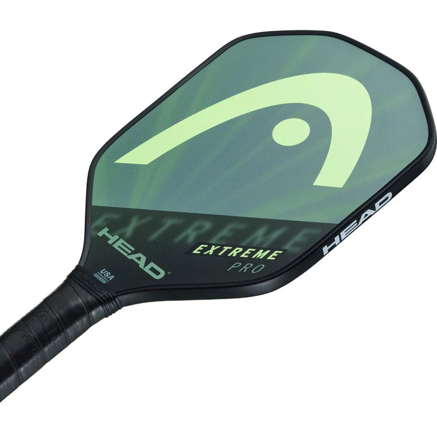 Close-up of the HEAD Extreme Pro 2023 Pickleball Paddle in black and green, featuring a Comfort Grip and composite surface with the HEAD logo and "EXTREME PRO" branding on the paddle face.