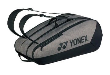The Yonex 42529EX Team 9 Racket Tennis Bag in gray and black boasts two shoulder straps, an oval shape, multiple zippered compartments, and a side Yonex logo—ideal for transporting all your tennis gear.