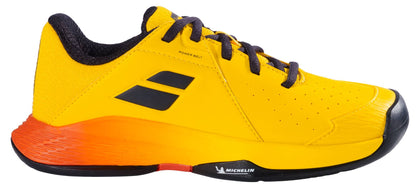 The Babolat Propulse Junior 3 All Court Boys Tennis Shoes in Yellow/Sunset feature a bold geometric design, black laces, a durable Michelin outsole with tread pattern, orange gradient heel, and “MICHELIN” logo on the sole.