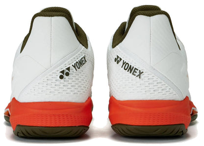The Yonex Power Cushion Ad-Accel Men's Tennis Shoes in white and orange feature olive green outsoles, the Yonex logo on the heels, and are designed for speed on the court.