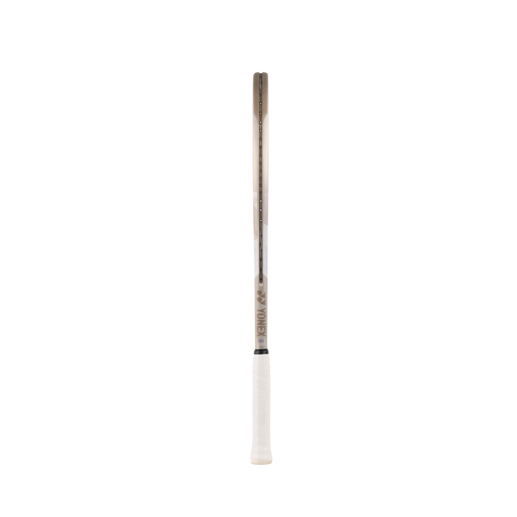 The Yonex VCORE Game Tennis Racket in Sand Beige stands against a plain white backdrop, featuring a white grip and brownish frame. Its design reflects the innovative style of VCORE rackets, combining classic aesthetics with modern performance, with "Yonex" on the side.
