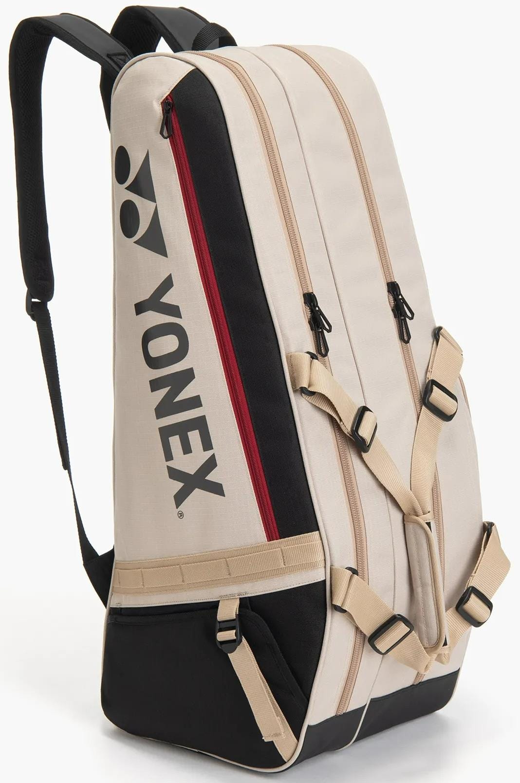 The Yonex BA72626EX Gearlogic 6 Racket Tennis Bag in beige and black features multiple zippered compartments, a red accent zipper, black Yonex logo, adjustable padded straps, and stands upright on a white background.