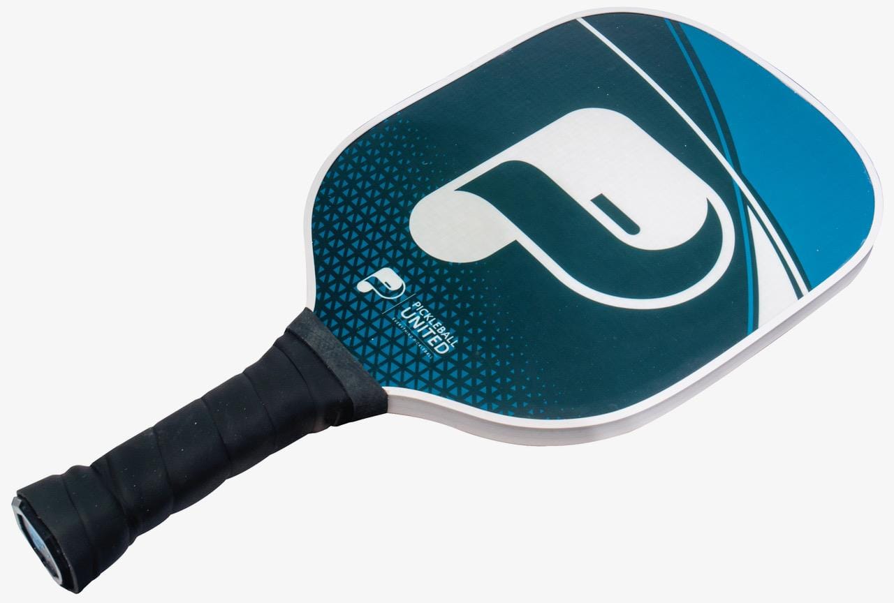 The Pickleball United Freedom Pickleball Paddle in black and blue features a black grip, large white "P" logo, geometric face patterns, and a durable fiberglass hitting surface for enhanced play.