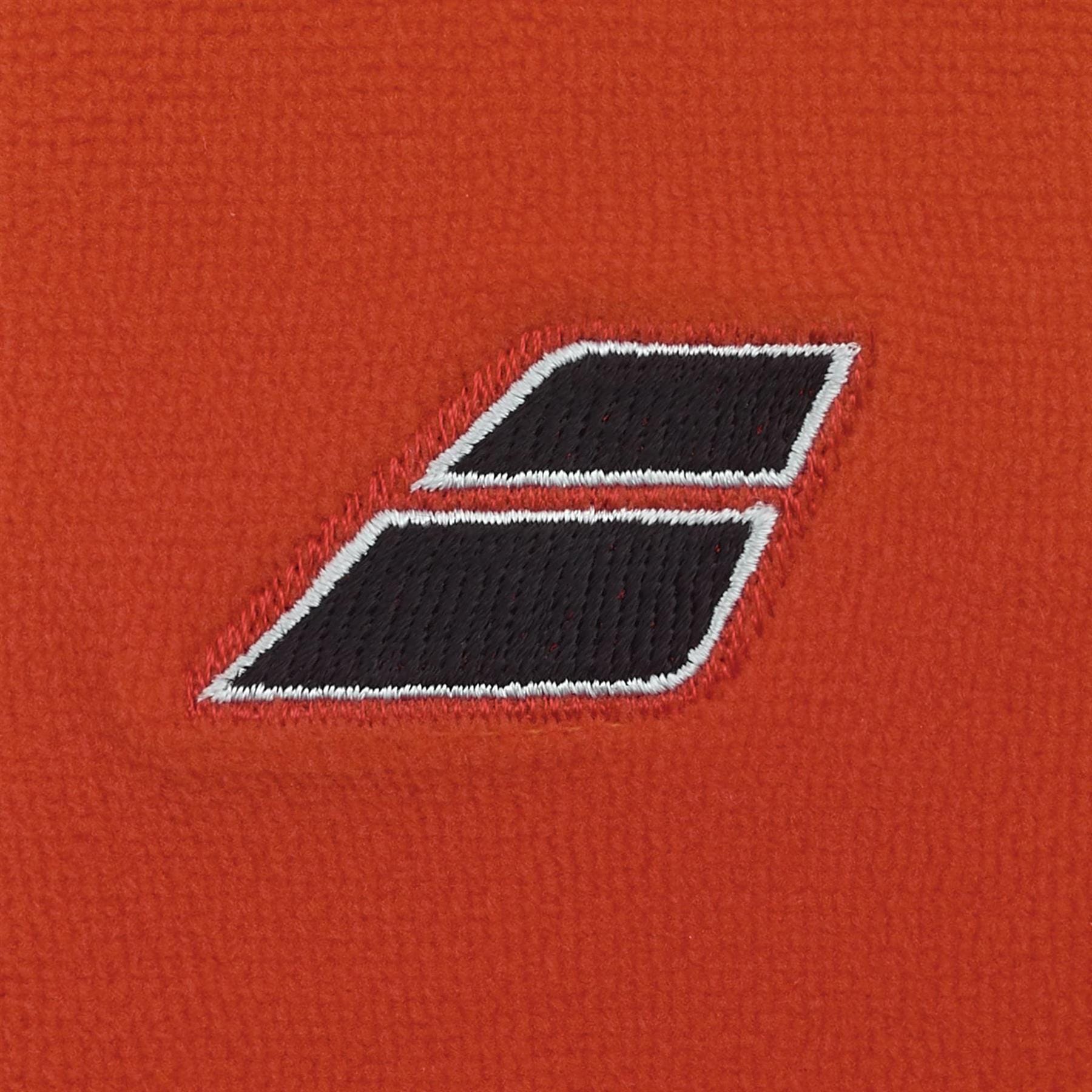 Close-up of two Babolat Terry Jumbo Wristbands in Cherry Tomato, featuring a black parallelogram shape with white borders, stitched onto orange textured fabric. The large wristbands slightly overlap and angle to the right.