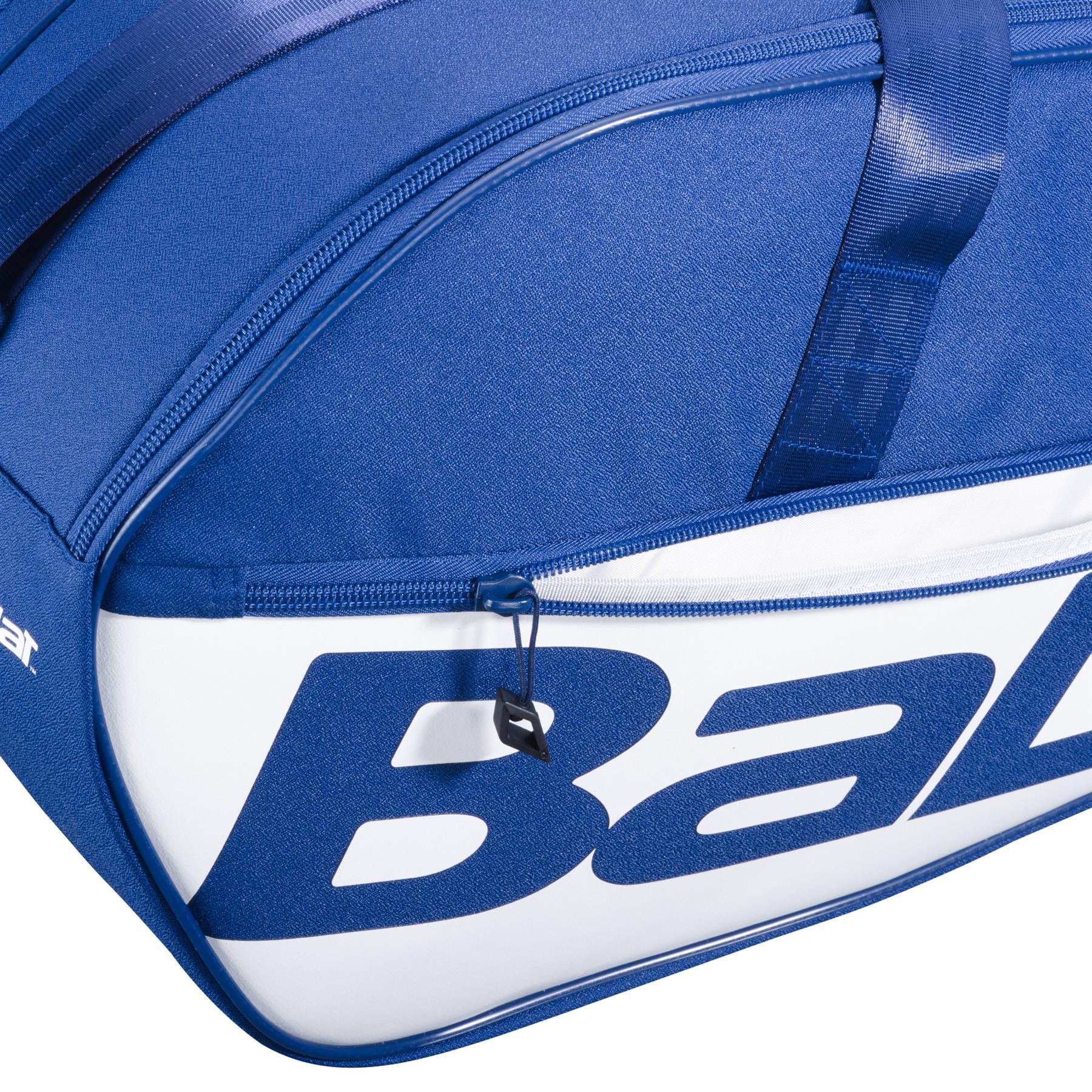 Close-up of the Babolat Court M 6 Racket Tennis Bag in dark blue, featuring a visible zipper and part of the large blue "Babolat" branding on the side.