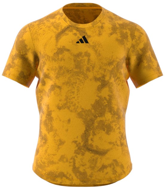 The ADIDAS Paris Men's Freelift Tennis T-Shirt in Gold/Yellow features short sleeves, a striking dark abstract pattern, and an understated black triangular logo on the chest. Enhanced with HEAT.RDY technology, this T-shirt from adidas is showcased against a plain background.