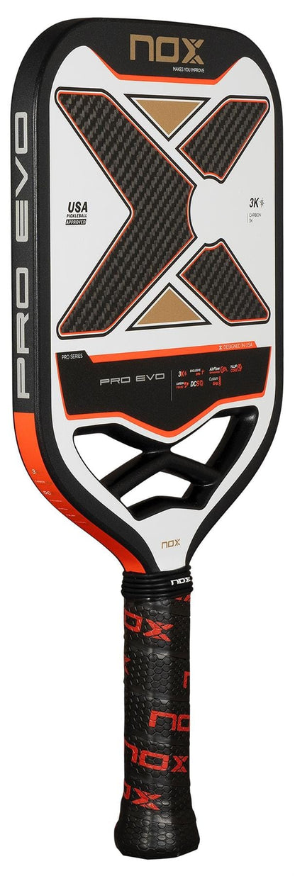 The NOX Pro Evo Pickleball Paddle - Black / Red by NOX features a bold "X" design, red and white accents, 3K carbon fibre details, Exclusive Spin technology, and distinctive branding for top performance.