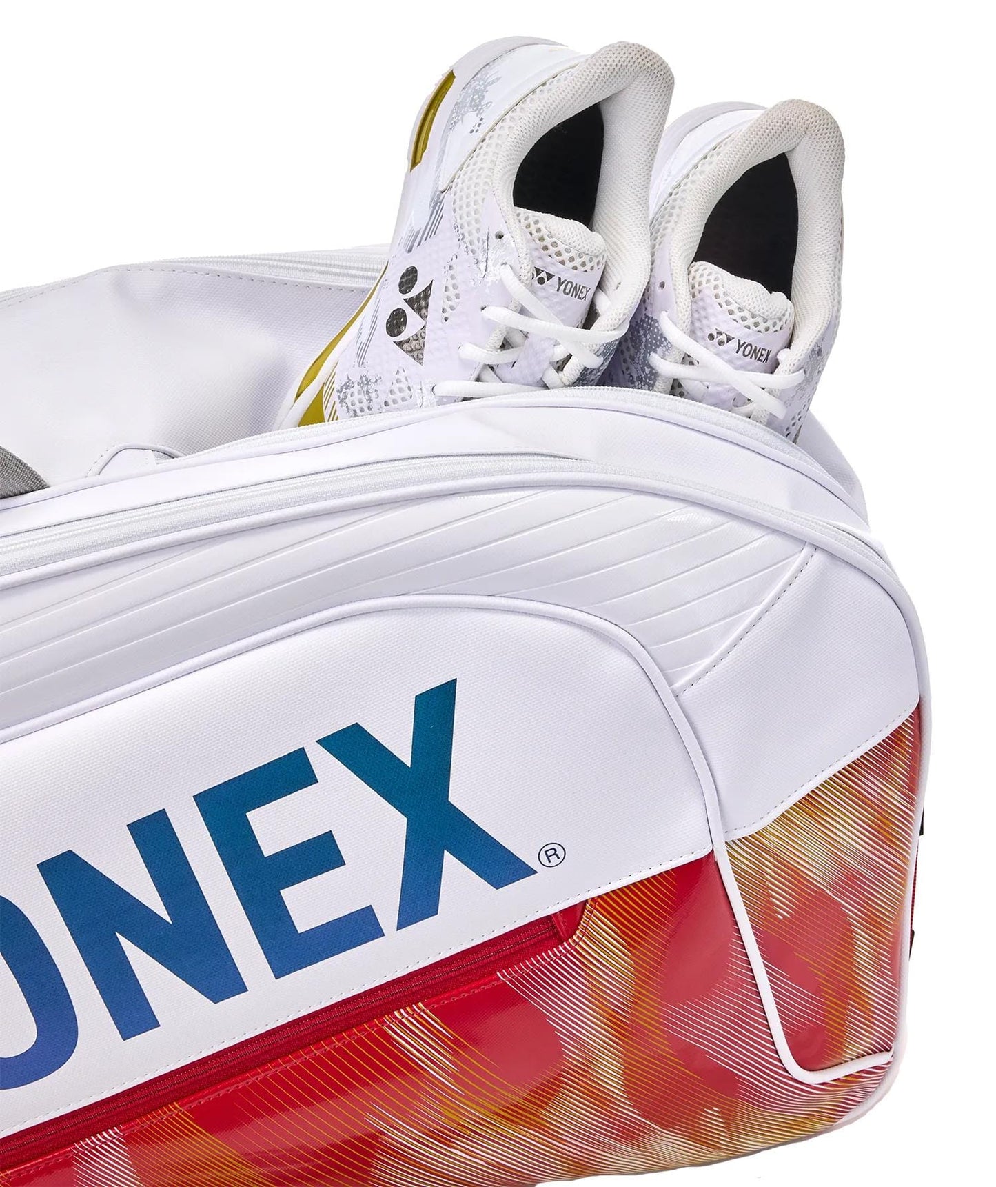 A pair of white Yonex sports shoes are stored inside the Yonex 02626EX Expert 6 Racket Tennis Bag - White, featuring red and orange patterns, spacious racket storage, and a prominent Yonex logo on the side.