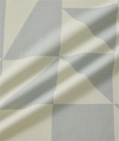Close-up of light gray and off-white geometric patterned fabric on the Yonex 10712YX Crew Neck Men's Tennis T-Shirt in Champagne, showing its textured surface and soft folds—perfect for sports performance.