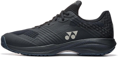 The Yonex Power Cushion Sonicage Men's Tennis Shoes in Black/Mocha Grey feature textured details, laces, a low-profile design, two white circular side logos, and a patterned sole—perfect for sports or casual wear.