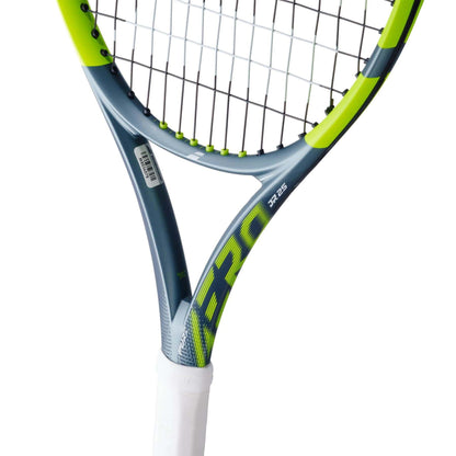 Close-up of the Babolat Pure Aero Junior 25 Tennis Racket 2026 by Babolat, featuring a grey and neon yellow frame, white grip, and black strings. "AERO" appears on the shaft, showcasing its advanced spin technology for junior players.