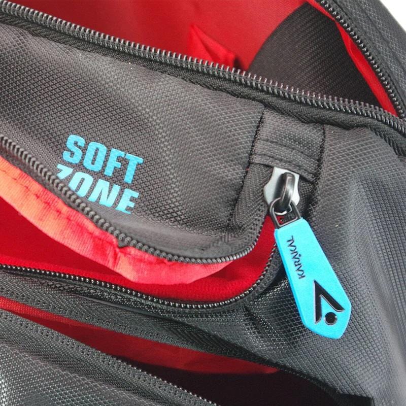 Close-up of a black zippered bag with a vibrant red interior, reminiscent of the Karakal Pro Tour 30 2.1 Tennis Backpack in Black and Blue. The blue zipper pull is labeled "KAVALAN," and the interior features "SOFT ZONE" in blue. This design reflects the spaciousness of a 30-liter capacity with plush comfort similar to padded shoulder straps associated with Karakal's craftsmanship.